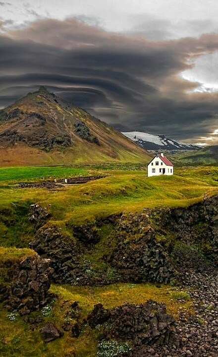 Weißes Haus in der weiten Landschaft auf einer Weide in Island