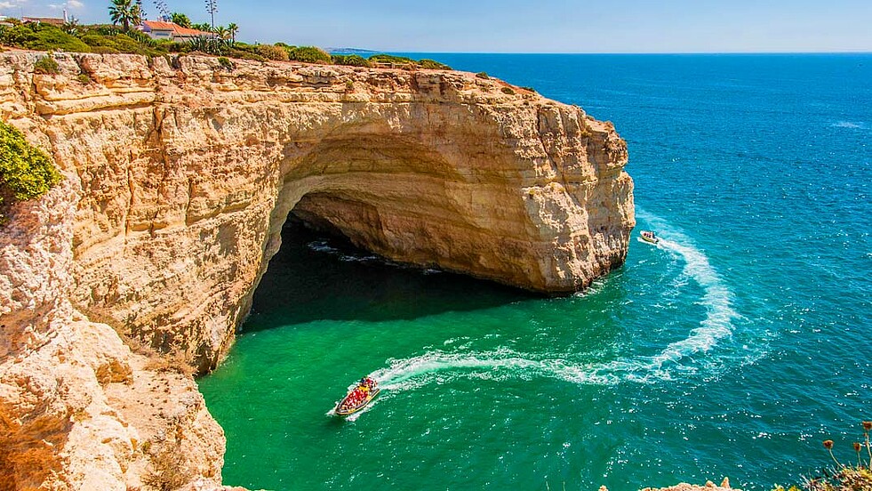 Boot vor Höhle in der Steilküste an der Algarve in Portugal auf der Reise Vasco da Gama