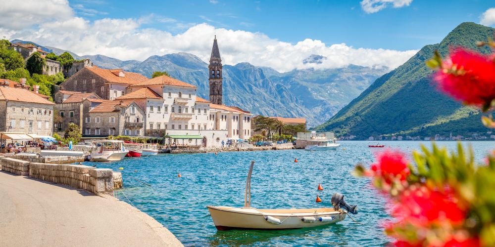 Hafen mit roten Blüten in Perast an der Bucht von Kotor in Montenegro