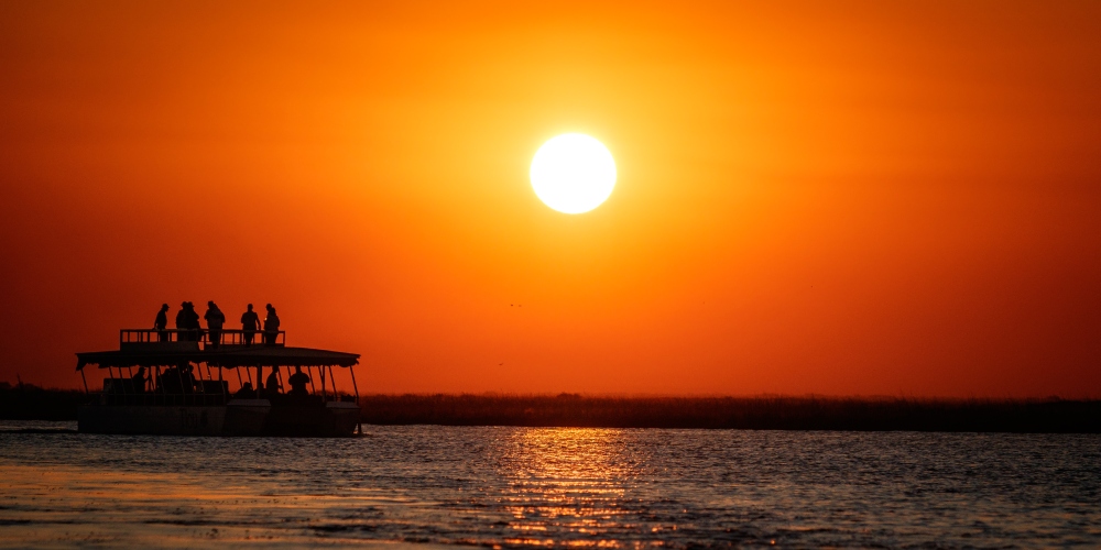 Boot auf dem Chobe bei Sonnenuntergang im Chobe Nationalpark in Botswana