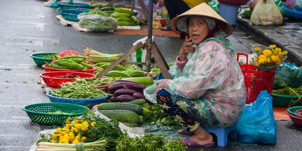 Gemüseverkäuferin auf Markt in Hoi An, Vietnam