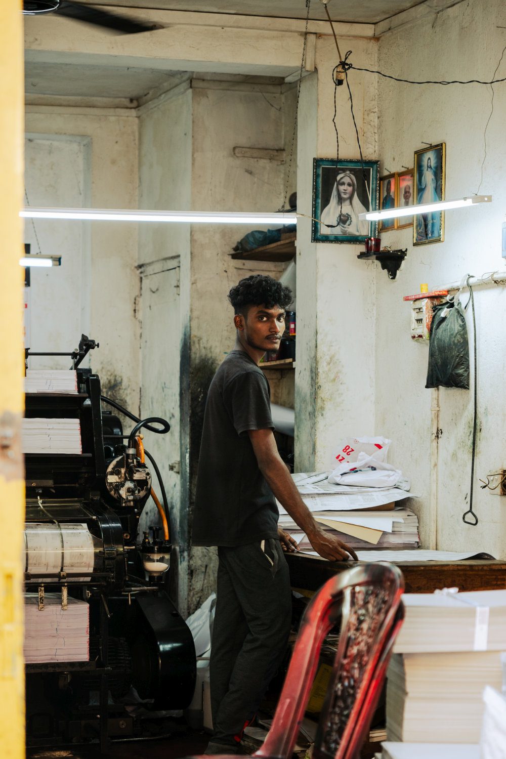 Junger Mann bei der Papierverarbeitung in einer Druckerei in Sri Lanka