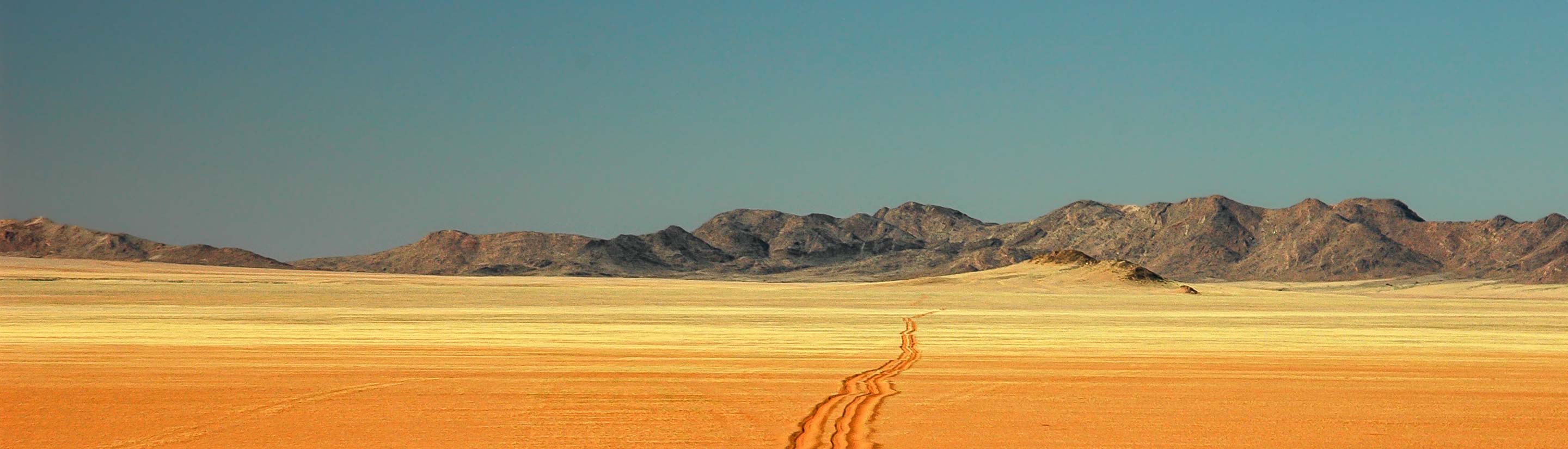 Weite gelbe Sandstraße in Namibia